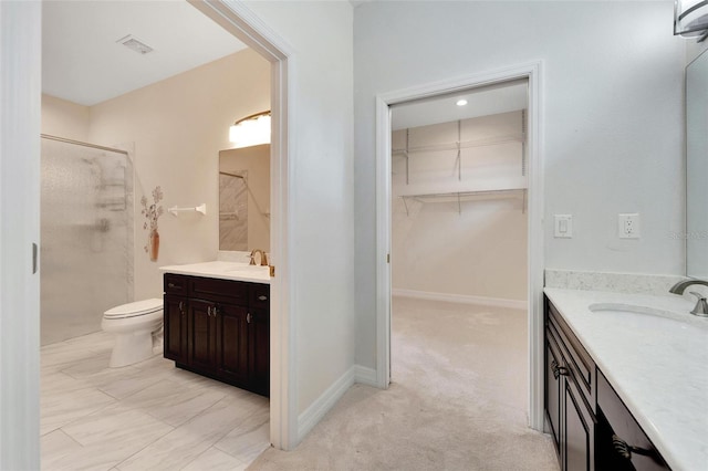 bathroom featuring vanity, an enclosed shower, and toilet