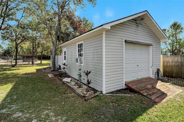 exterior space featuring cooling unit, a yard, an outbuilding, and a garage