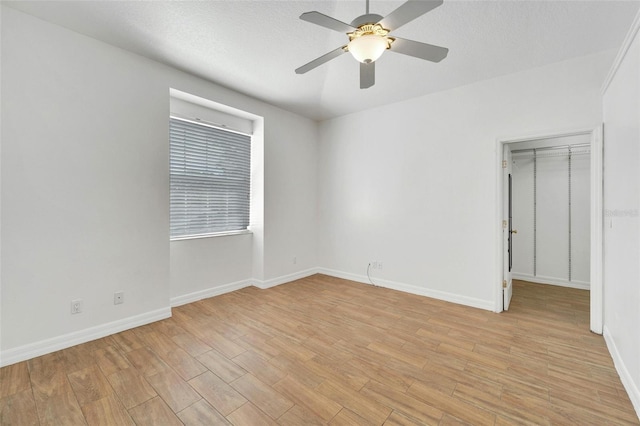 empty room with a textured ceiling and ceiling fan