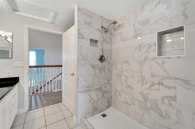 bathroom featuring tile patterned flooring, vanity, and tiled shower