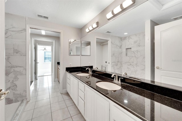 bathroom featuring tile patterned flooring, vanity, and a textured ceiling