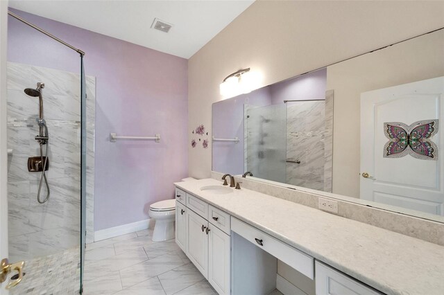 bathroom with vanity, toilet, and a tile shower