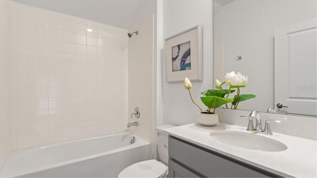 full bathroom featuring tiled shower / bath combo, toilet, and vanity