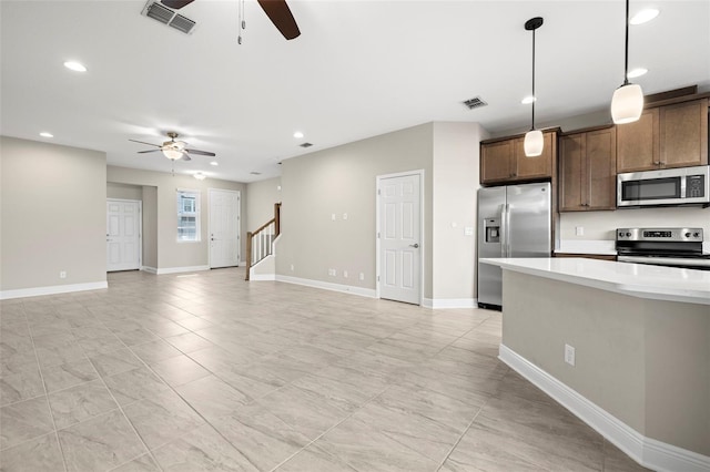 kitchen featuring pendant lighting, ceiling fan, and appliances with stainless steel finishes