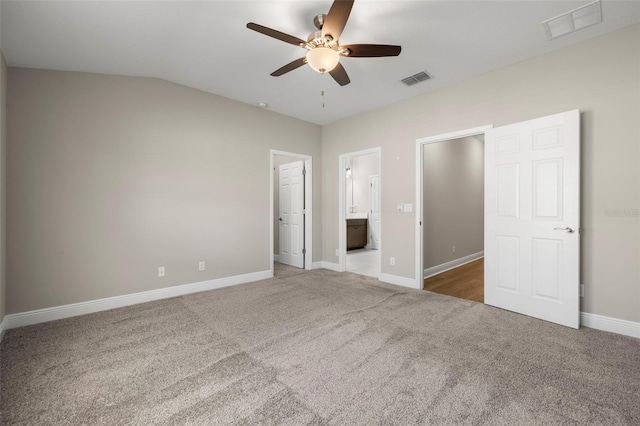 unfurnished bedroom featuring ensuite bath, ceiling fan, carpet, and lofted ceiling