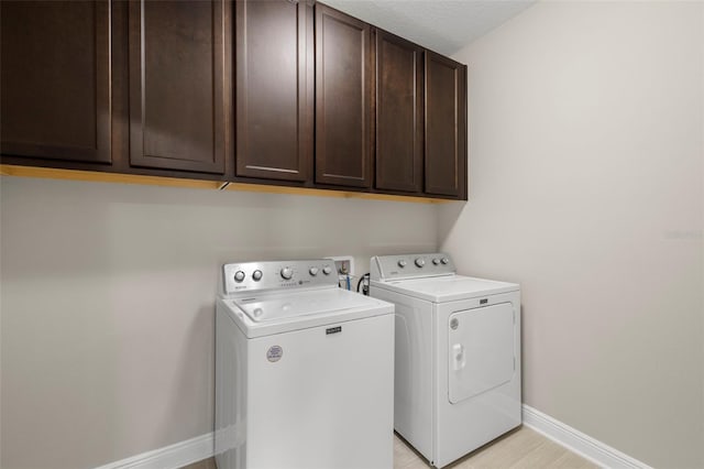 laundry area with cabinets and washer and clothes dryer