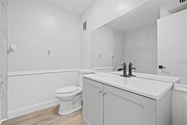 bathroom with vanity, hardwood / wood-style flooring, and toilet