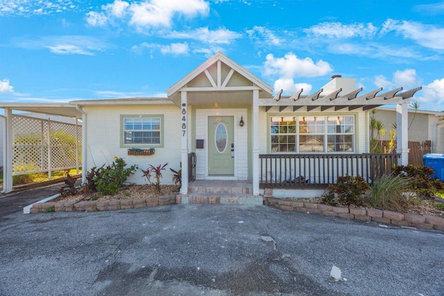 view of front of property featuring covered porch and a carport