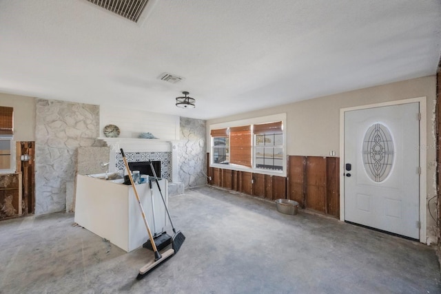 living room featuring a textured ceiling, concrete flooring, and a fireplace