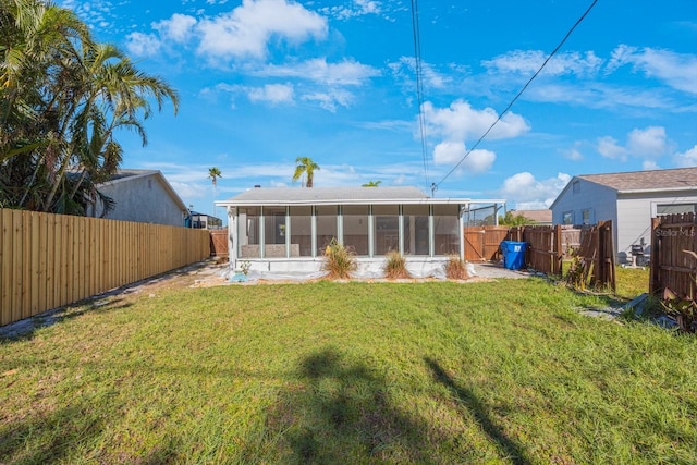 back of house featuring a sunroom and a yard