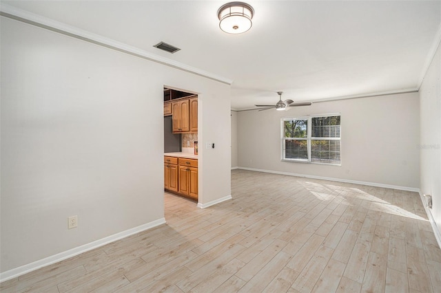 unfurnished living room featuring ceiling fan, light wood-type flooring, and ornamental molding