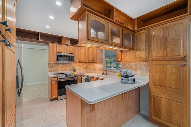 kitchen featuring kitchen peninsula, light hardwood / wood-style floors, and appliances with stainless steel finishes