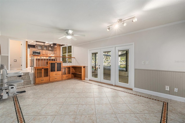 unfurnished living room featuring ceiling fan, french doors, light tile patterned floors, and ornamental molding