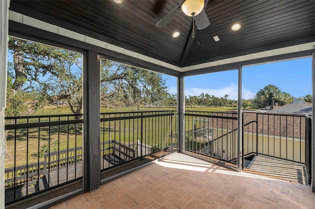 unfurnished sunroom with vaulted ceiling, ceiling fan, and wooden ceiling