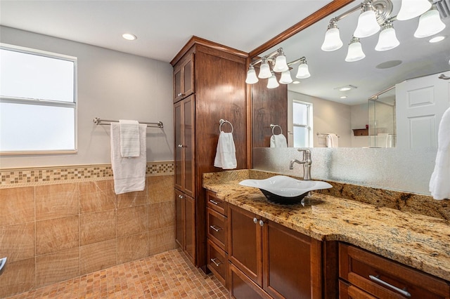 bathroom with vanity, a shower, and tile walls