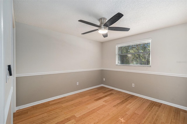 empty room with a textured ceiling, hardwood / wood-style flooring, and ceiling fan