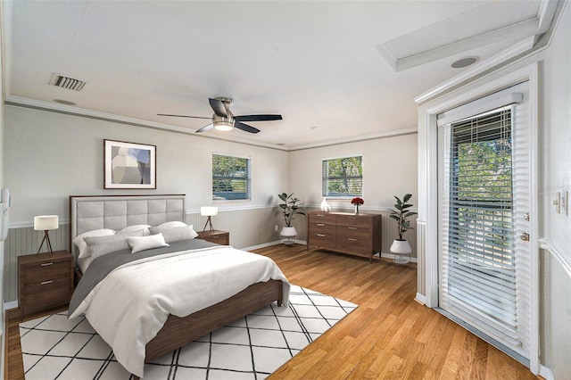 bedroom featuring ceiling fan, light hardwood / wood-style floors, access to exterior, and ornamental molding