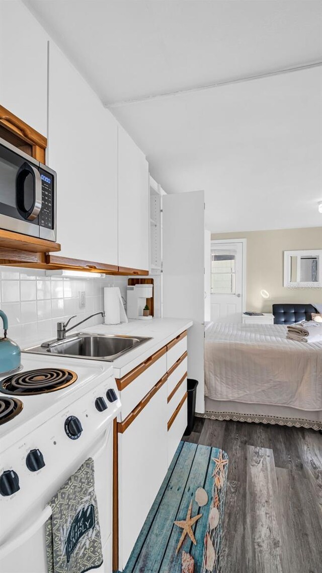 483 E Shore Dr Unit D3, Clearwater Beach, FL 33767 - kitchen featuring white range with electric stovetop, white cabinetry, dark wood-style floors, light countertops, and tasteful backsplash