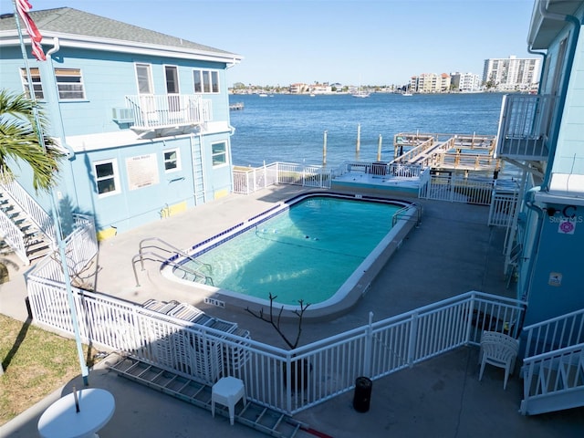 view of pool featuring a water view and a patio area