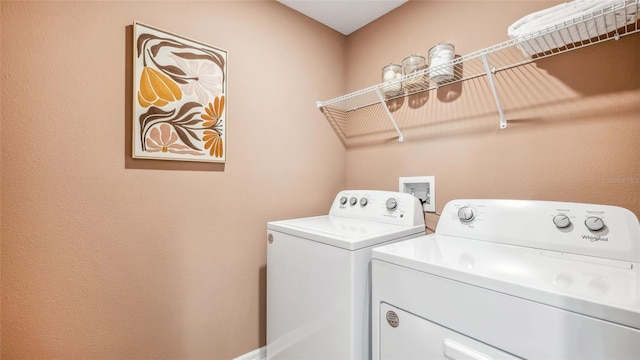 clothes washing area with separate washer and dryer