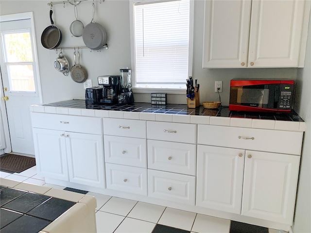 kitchen with white cabinetry, tile counters, and plenty of natural light