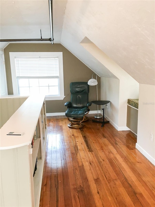 bonus room featuring vaulted ceiling and hardwood / wood-style flooring