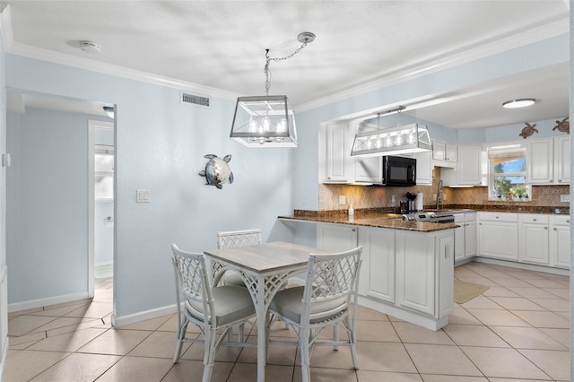 kitchen featuring white cabinets, decorative light fixtures, backsplash, kitchen peninsula, and light tile patterned flooring