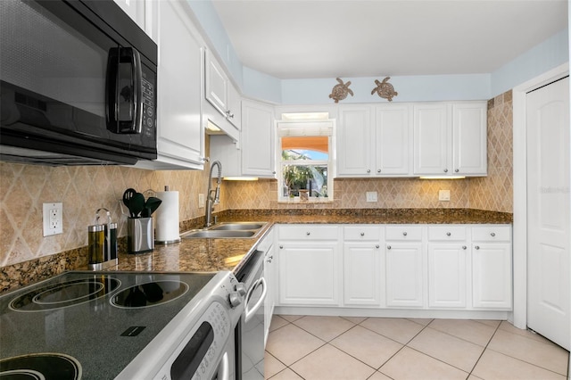 kitchen featuring light tile patterned floors, sink, white cabinets, and range