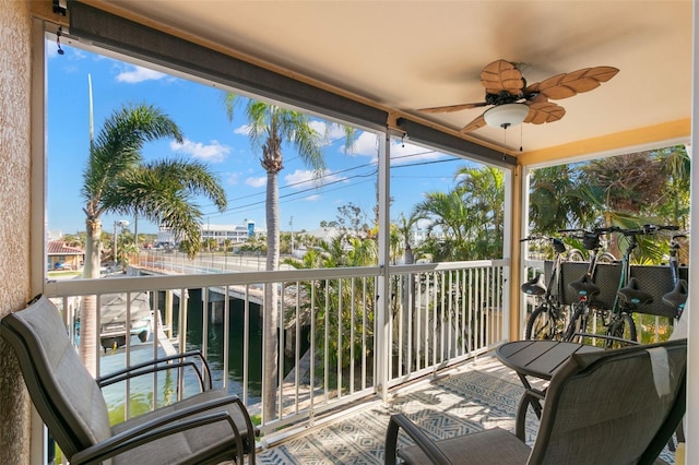 balcony with ceiling fan and a water view