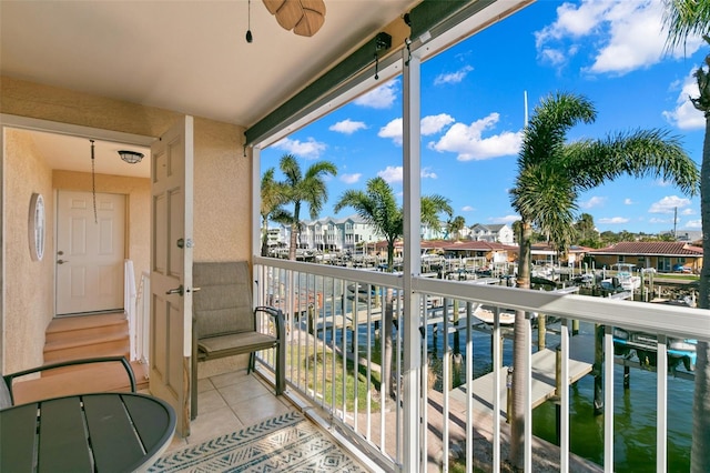 balcony with ceiling fan and a water view