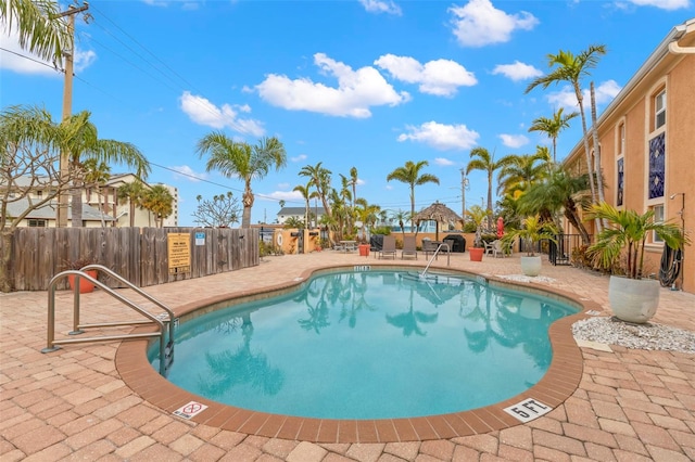 community pool with fence and a patio