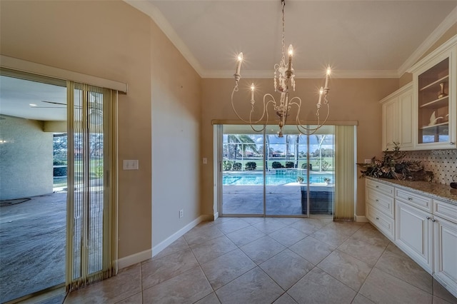 unfurnished dining area featuring light tile patterned flooring, ornamental molding, and an inviting chandelier