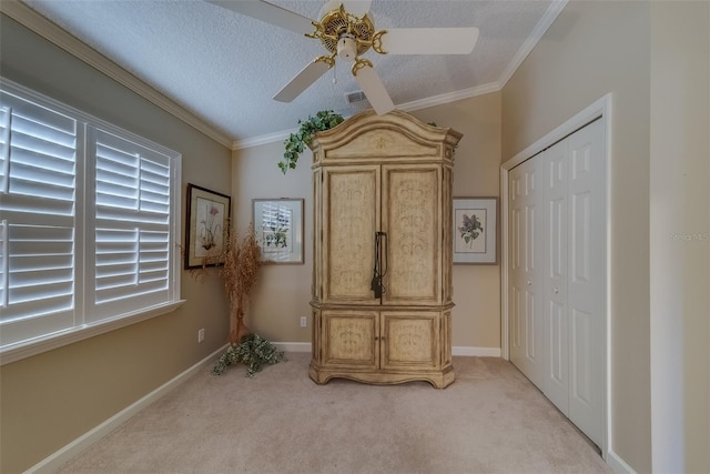 bedroom with a textured ceiling, ceiling fan, crown molding, and light carpet