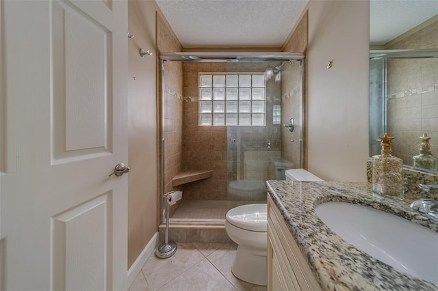 bathroom with vanity, tile patterned floors, toilet, a textured ceiling, and walk in shower