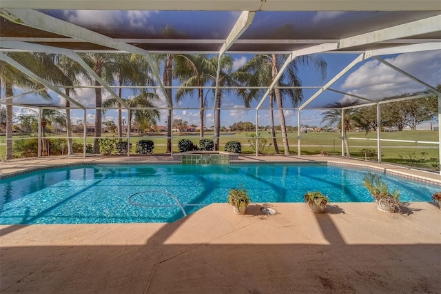 view of pool with glass enclosure and a patio