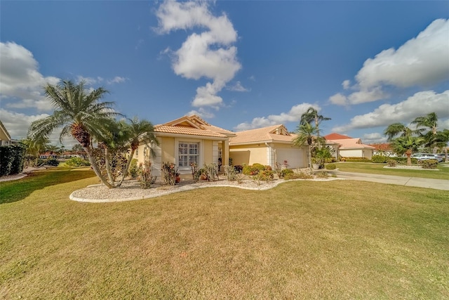 mediterranean / spanish home with a front lawn and a garage