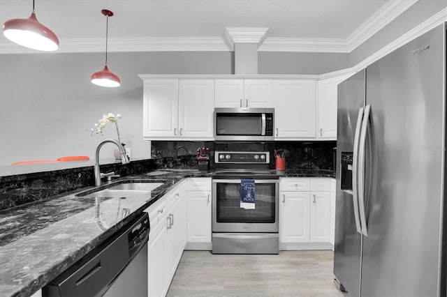 kitchen with white cabinets, sink, dark stone countertops, decorative light fixtures, and stainless steel appliances