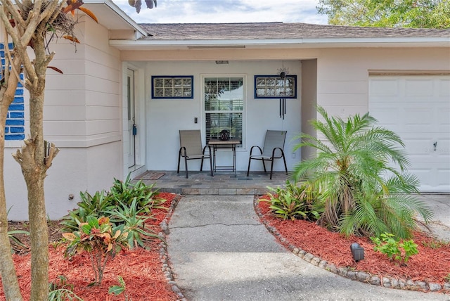 entrance to property with covered porch and a garage