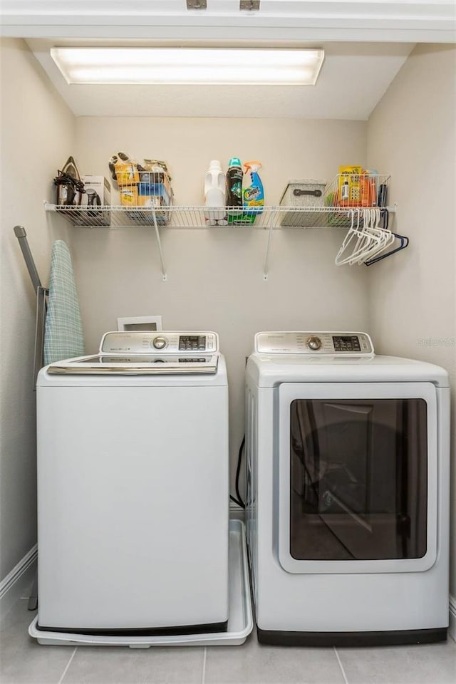 clothes washing area with separate washer and dryer and light tile patterned floors