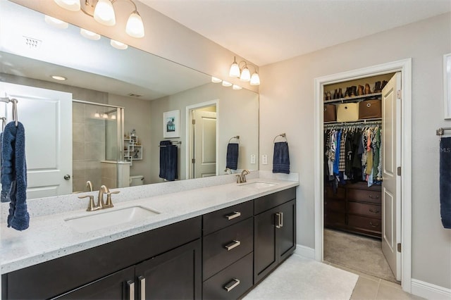 bathroom with tile patterned flooring, vanity, toilet, and an enclosed shower