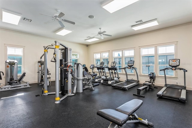 gym featuring ceiling fan, a healthy amount of sunlight, and ornamental molding