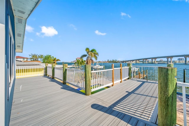 wooden terrace featuring a dock and a water view