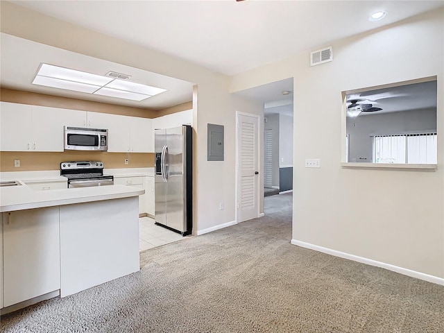 kitchen with electric panel, white cabinetry, stainless steel appliances, and light carpet