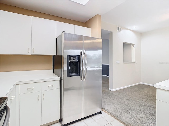 kitchen with white cabinets, stainless steel appliances, and light carpet