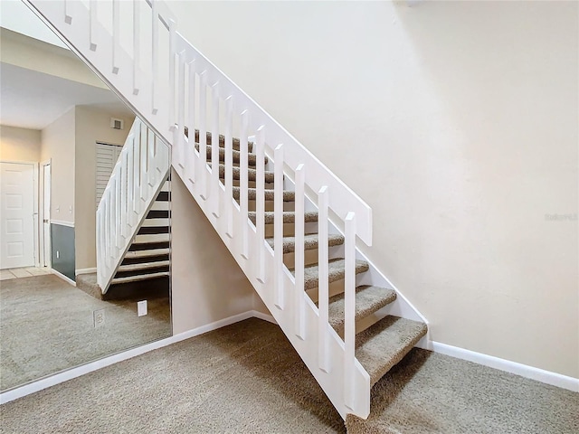 staircase featuring carpet flooring