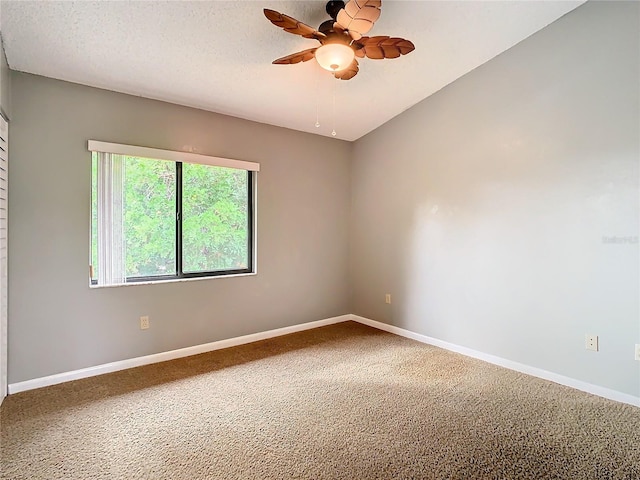 carpeted empty room featuring ceiling fan and a textured ceiling