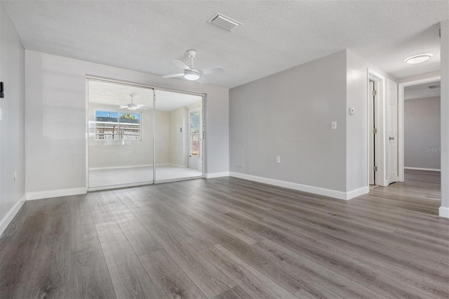 spare room with ceiling fan, a textured ceiling, and hardwood / wood-style flooring