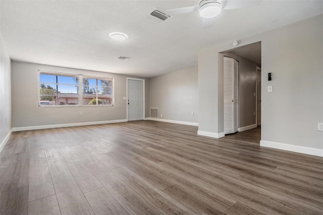 spare room featuring ceiling fan, dark hardwood / wood-style flooring, and a textured ceiling