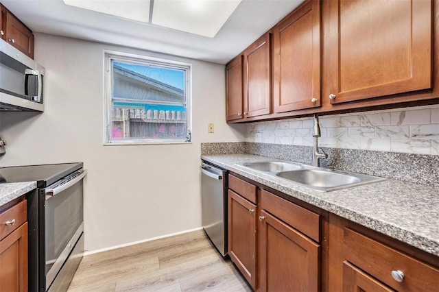 kitchen featuring backsplash, sink, light hardwood / wood-style floors, and appliances with stainless steel finishes