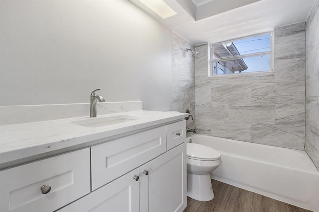 full bathroom with hardwood / wood-style flooring, vanity, toilet, and tiled shower / bath combo